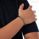 Person wearing a bracelet on a plain background